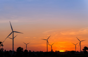 Eco power in wind turbine farm with sunset