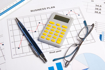 Naklejka na ściany i meble close up of business plan with graphs, charts, glasses, pen and