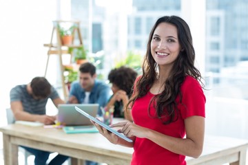 Smiling young businesswoman using tablet