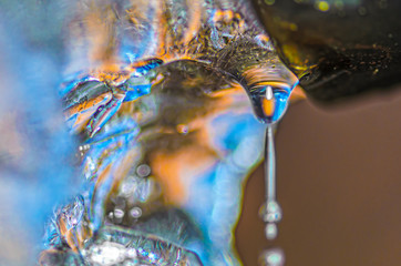 Drop of melting ice water from drainpipe