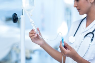 Nurse connecting an intravenous drip - obrazy, fototapety, plakaty
