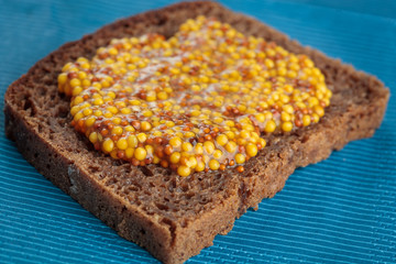 Slice of rye bread with wholegrain mustard
