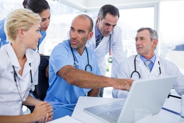 Doctor showing laptop pc to his colleagues 