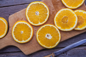 Cut oranges on wooden cutting board