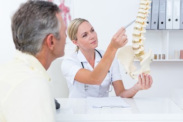 Doctor showing her patient a spine model