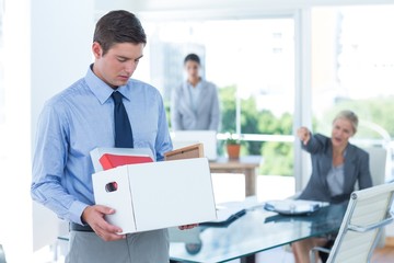 Businessman carrying his belongings in box