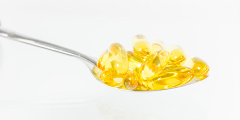 Omega 3 fish oil capsules on spoon