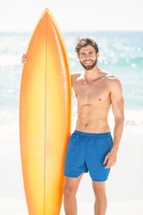 Handsome man holding surfboard 