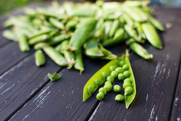 Fresh green peas scattered on the beautiful old wooden background
