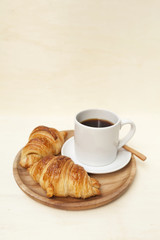 Golden brown croissant and black coffee