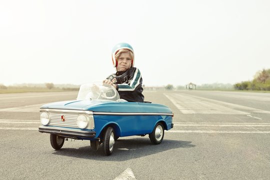 Boy in pedal car on race track