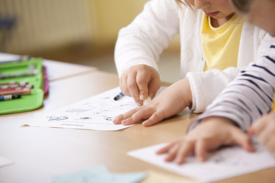 Schoolgirls working on work sheets in classroom