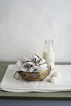Bowl of chocolate ornate meringue and bottle of milk