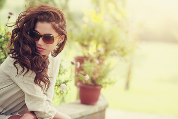 Smiling summer woman with sunglasses in italian garden