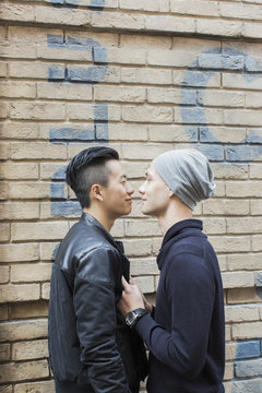 China, Hong Kong, gay couple at house wall