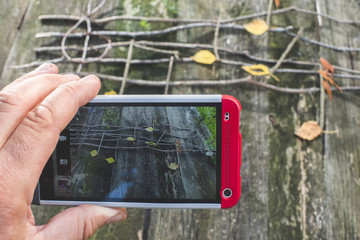 Person taking cell phone picture of wooden musical notes