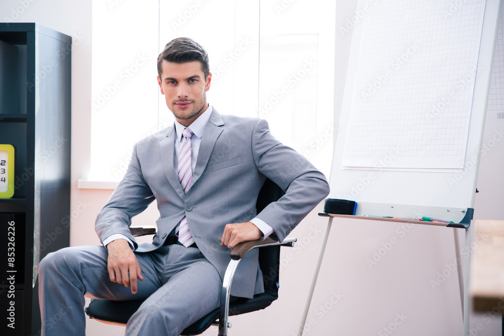 Sticker Handsome businessman sitting on the office chair