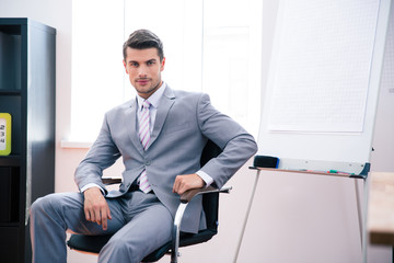 Handsome businessman sitting on the office chair