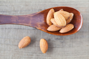 Almond in wood spoon on wood table background