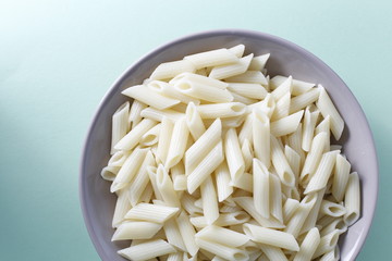 White Italian pasta on a bowl in a blue soft background