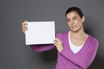 beautiful young woman holding a claim on blank communication board