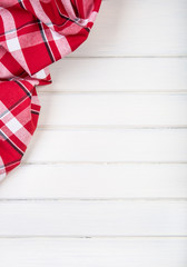 Obraz premium Top view of checkered kitchen towels on wooden table. 