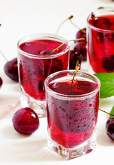 Homemade cherry liqueur and fresh cherries, selective focus