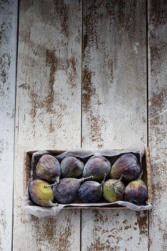 Cardboard box of figs on wood