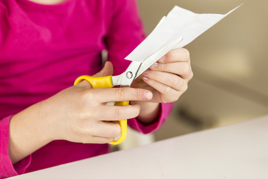Girl cutting piece of paper