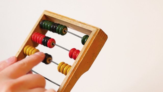 Hands calculate on abacus