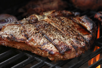 Porterhouse steak on a barbecue, shallow depth of field.
