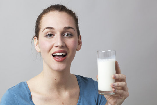 happy young woman enjoying holding a glass of milk for freshness