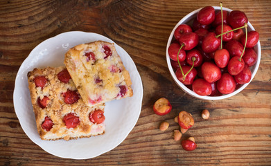 Ripe organic homegrown cherries and cherry cake, on wooden background