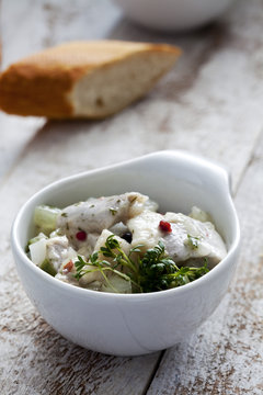 Bowl of pickled herring salad with cress