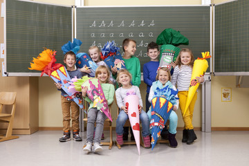 Group of happy pupils with school cones in classroom