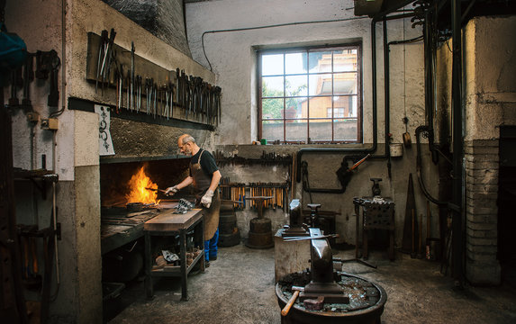 Senior blacksmith working in hammer mill