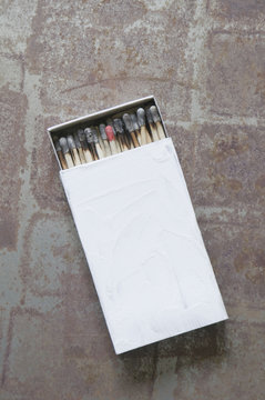 Matchbox with burnt matches except one