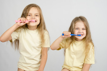 Two sisters brushing their teeth