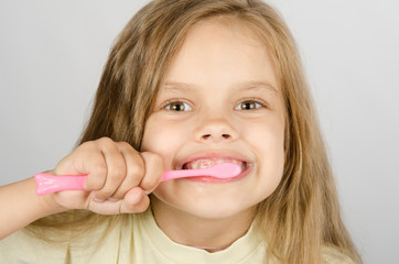 Six year old girl brushing her teeth