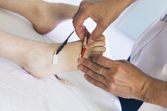 Chiropractor performing a foot electrotherapy