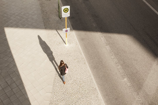 Young woman walking to bus stop
