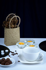 Empty coffee cup,coffee beans and candles on a table