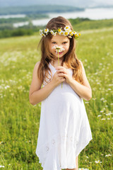 Cute child girl is holding daisy flower