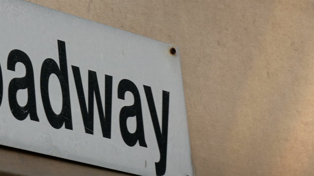 A 1a Broadway sign from the wall. It is in white board with black color fonts