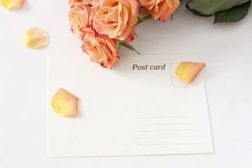 A post card with rose petals and tender tea roses in the background