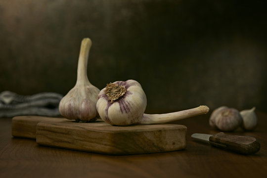 Two garlic bulbs on wooden board