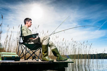 Crédence de cuisine en verre imprimé Pêcher Homme pêchant au lac assis sur la jetée