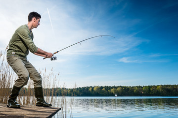 Pêcheur attrapant des poissons à la ligne au lac