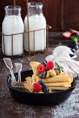Thin pancakes with apples and fresh berry