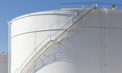 white tanks in tank farm with iron staircase